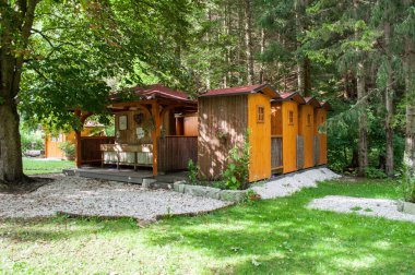 Slovenya 'nın Kransjak Gora kasabası yakınlarındaki bir kampta banyo ve tuvalet olarak hizmet veren ormandaki ahşap evler.
