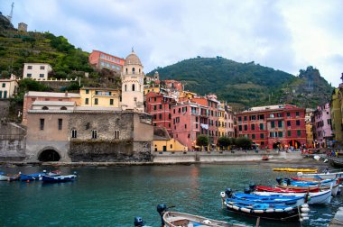 Akşamları Vernazza kasabasında küçük tekneleri, limanları ve renkli kuleleri olan renkli evleri olan Cinque Terre 'de (İtalya).).