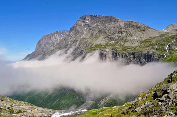 ノルウェーの有料道路 山や谷を通る狭い曲がりくねった道 夏の天気 岩の周りの雲 — ストック写真