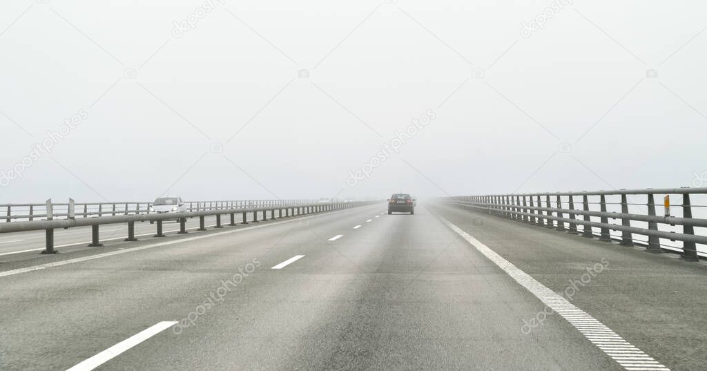 The Oresund bridge over the sea connecting Sweden and Denmark is lost in the fog