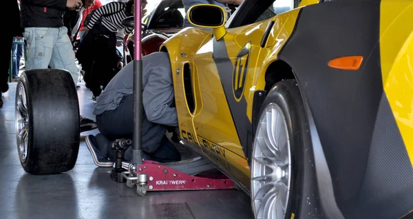 Mechanik Naprawia Rower Żółtym Boxing Samochód Wyścigowy Torze Wyścigowym Brnie — Zdjęcie stockowe