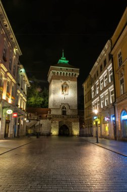 Krakow, Polonya - 18 Temmuz 2016: Eski kentin ana caddelerinden biri kaldırımda yanan binalar ve yansımalarla ana meydana çıkıyor