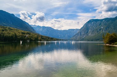 Slovenya 'daki Bohinj Gölü. Güzel doğa, büyük göl ve yüksek dağlar. Deniz kenarında yüzmek ve dinlenmek için yaz havası.