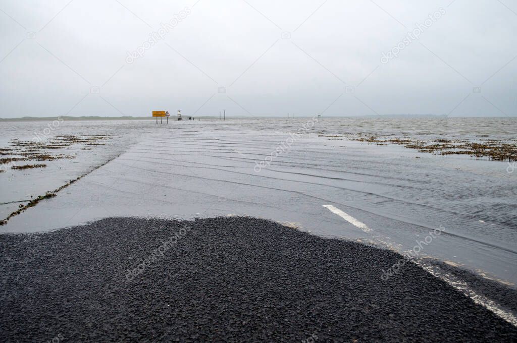 Road to Holy Island in England flooded by the sea at high tide.