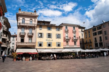 Lugano, İsviçre - 23 Ağustos 2013: Yazın meydanında dükkanları ve restoranları olan eski renkli evler.