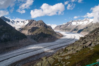 Uzun bir Aletschgletscher buzulu, yüksek dağlar arasındaki dar bir vadi boyunca uzanır (İsviçre)