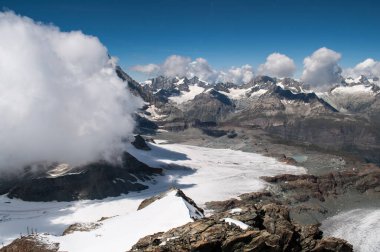 Matterhorn ve yüksek karlı dağları süpüren büyük beyaz bir bulut (Zermatt, İsviçre)