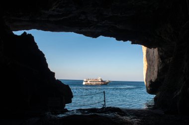 Sardunya adasındaki Neptün Mağarası 'ndan görünen, deniz yoluyla seyahat eden bir gemi.