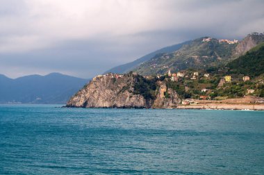 Corniglia 'da deniz üzerindeki bir kayanın üzerinde renkli evleri olan kıyılar (İtalya, Cinque Terre)