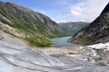 Kuzey Avrupa 'daki Norveç ile Jostedalsbreen Ulusal Parkı' ndaki kayaların arasında bir göl bulunan derin buzul vadisi..