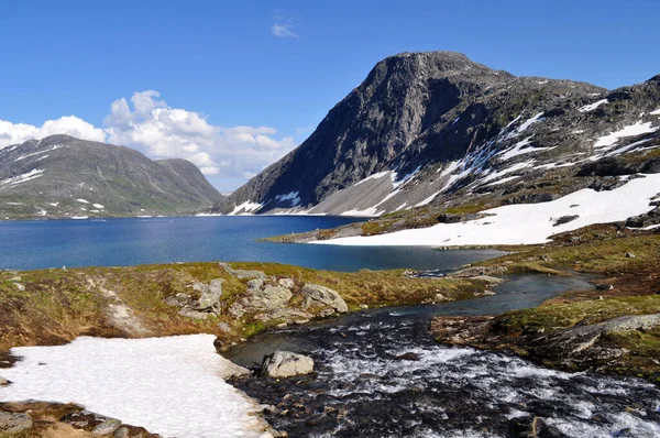 Norveç 'in Romsdal bölgesinde Dalsnbba Tepesi' nin aşağısında buzdan gölü olan karlı dağlar.