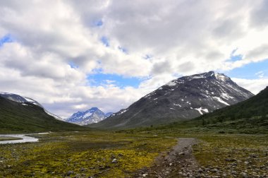 Norveç, Galdhopiggen Ulusal Parkı 'ndaki derin vadi. Nehir ve yürüyüş yolu.