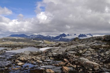 Sognefjell, Jotunheim, Norveç. Doğal parktaki karlı kayalık arazi. Karla kaplı kayalar, dağlar ve buzlu göller..