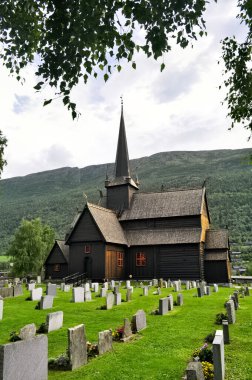Lom, Norveç. Çimen ve mezar taşları olan eski ahşap bir kilise. Sandinavi, Avrupa 'da tarihi eser ve turistik cazibe.