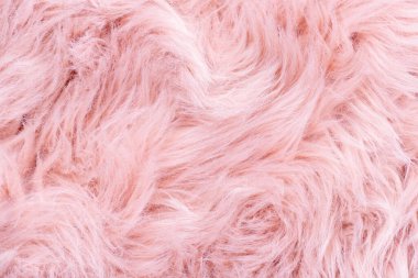 Pembe kürk desenli üst görünüm. Pembe koyun derisi arka plan. Kürk deseni. Pembe tüylü kürk dokusu. Yün dokusu. Koyun kürkü yakın.