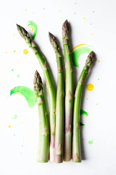 Creative layout made of asparagus. Fresh green asparagus on white  watercolor background. Vegan healthy food concept. Top view