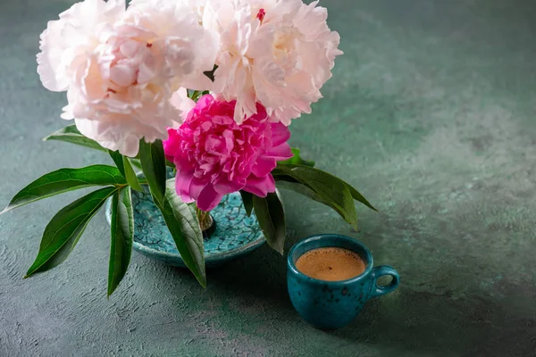 咖啡杯 桌上放着一束牡丹花 一杯咖啡浓缩咖啡 配上绿色背景的花卉配料 复制空间 — 图库照片