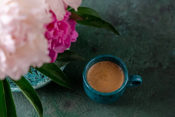 咖啡杯 桌上放着一束牡丹花 一杯咖啡浓缩咖啡 配上绿色背景的花卉配料 复制空间 — 图库照片