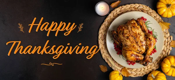 Happy Thanksgiving holiday background. Roasted whole chicken or turkey with autumn vegetables for thanksgiving dinner on dark background