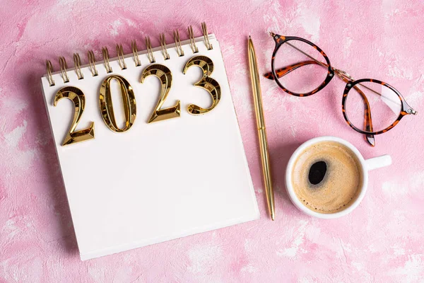 New year resolutions 2023 on desk. 2023 resolutions list with notebook, coffee cup on table. Goals, resolutions, plan, action, checklist concept. New Year 2023 template, copy space