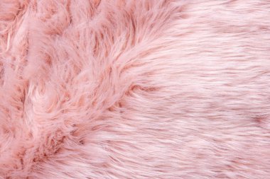 Pembe kürk desenli üst görünüm. Pembe koyun derisi arka plan. Kürk deseni. Pembe tüylü kürk dokusu. Yün dokusu. Koyun kürkü yakın.