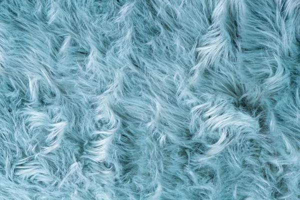 Trendy artificial fur texture. Fur pattern top view. Blue fur background. Texture of blue shaggy fur. Wool texture. Flaffy sheepskin close u