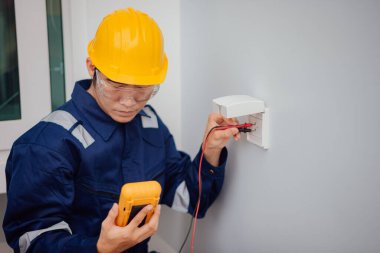 Elektrikçi çoklu metre üzerinden voltaj testi yapıyor..