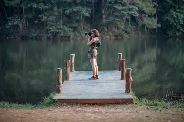 Uma Aventureira Está Tirando Uma Foto Lago Floresta Pinheiros Ponte — Fotografia de Stock