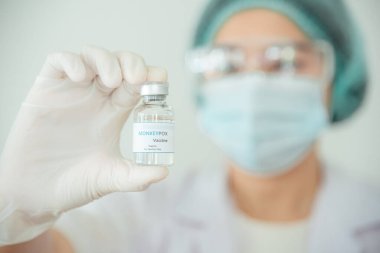 A doctor or scientist is holding a vaccine vial for monkeypox or clade.