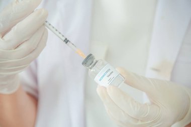 A doctor or scientist is holding a vaccine vial for monkeypox or clade.