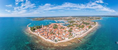 Hırvat kıyı kenti Novigrad üzerindeki insansız hava aracı panoraması, liman ve gezinti güvertesi gün boyunca deniz tarafından alındı