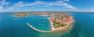 Hırvat kıyı kenti Novigrad üzerindeki insansız hava aracı panoraması, liman ve gezinti güvertesi gün boyunca deniz tarafından alındı