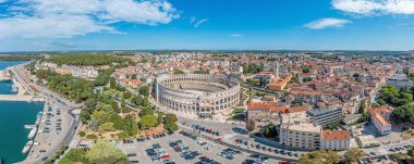 Drone panorama of the Croatian coastal city of Pula taken during the day above the harbor in summer clipart