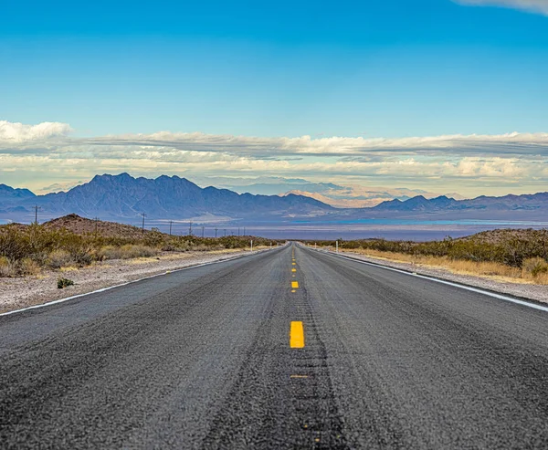 Panoramiczny obraz samotnej, pozornie niekończącej się drogi na pustyni — Zdjęcie stockowe