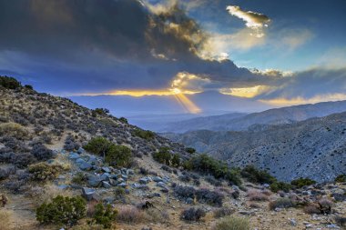 Bulutlardaki bir delikten geçen güneş ışınlarıyla muhteşem bir hava sahnesinin görüntüsü.