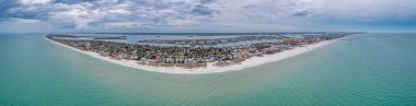 Florida Clearwater plajı üzerinde hava aracı panoraması. Baharda bulutlu bir hava var.