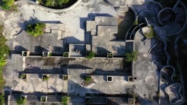 Gündüz vakti bir kasırga tarafından yıkılan tropik bir plajda lüks bir otelin enkazının dikey yükselme videosu. 