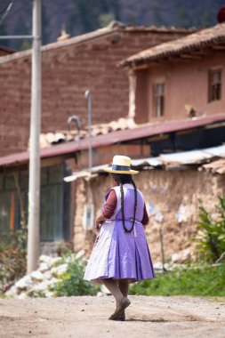 Urubamba Peru 'da And kasabasında yürüyen yaşlı bir kadın resmi. Peru And Dağları 'ndaki geleneksel köy.