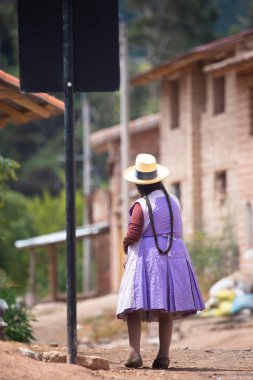 Urubamba Peru 'da And kasabasında yürüyen yaşlı bir kadın resmi. Peru And Dağları 'ndaki geleneksel köy.