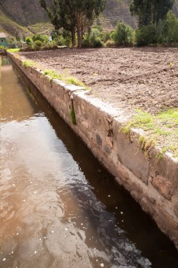 Yucay Peru 'daki su kanalı görüntüsü. İnka döneminden kalma ve hala tarım için işlevsel olan eski inşaat.