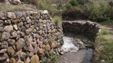 Yucay Peru 'daki su kanalı videosu. İnka döneminden kalma ve hala tarım için işlevsel olan eski inşaat.
