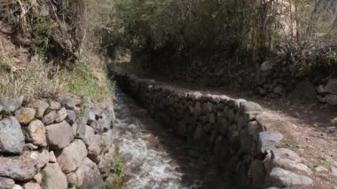 Yucay Peru 'daki su kanalı videosu. İnka döneminden kalma ve hala tarım için işlevsel olan eski inşaat.