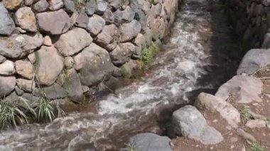 Yucay Peru 'daki su kanalı videosu. İnka döneminden kalma ve hala tarım için işlevsel olan eski inşaat.