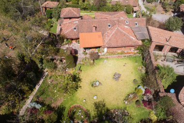 Aerial view of a rural house in the countryside of Cusco Peru. House in Yucay town with roof tiles.