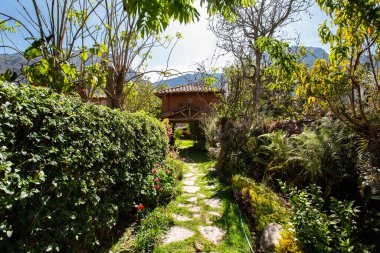 Corridor entrance in a rural house in the Peruvian Andes. Green corridor with stone path.
