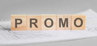 Promosyon hafif tahta bloklarda yazılır. Kelime, çizelgeler ve grafiklerle dolu bir sayfada yer almaktadır. İş konsepti. gri arkaplan