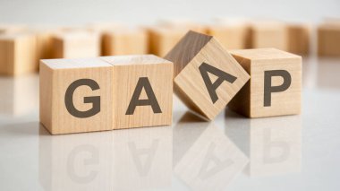 Genel olarak Muhasebe Uygulaması Kabul Edildi. Gri bir masadaki tahta küplere GAAP kelimesi. iş kavramı