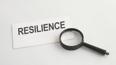 Beyaz kağıt kart ve büyüteç üzerindeki RESILICE sözcüğü