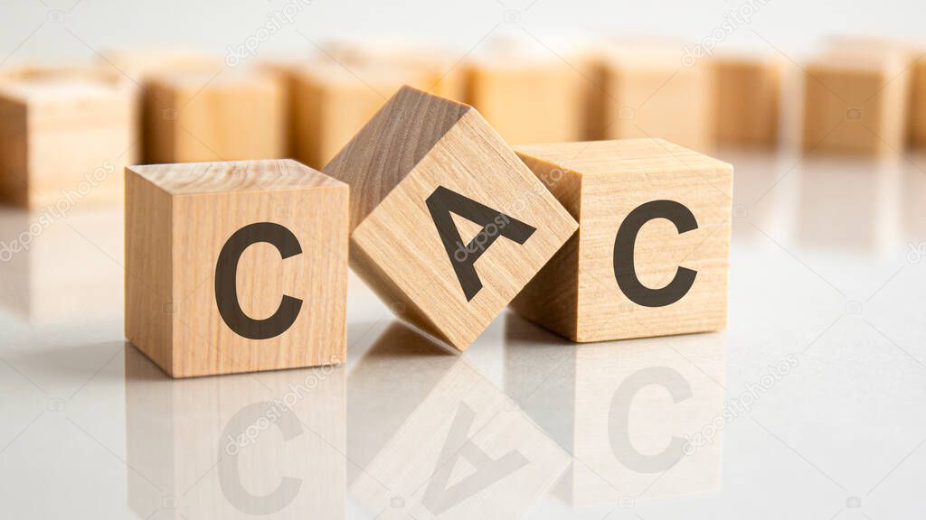 three wooden blocks with the letters CAC on the bright surface of a gray table. the inscription on the cubes is reflected from the surface of the table. cac - customer acquisition cost