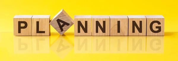 Planning word is made of wooden building blocks lying on the yellow table, concept — Stock Photo, Image